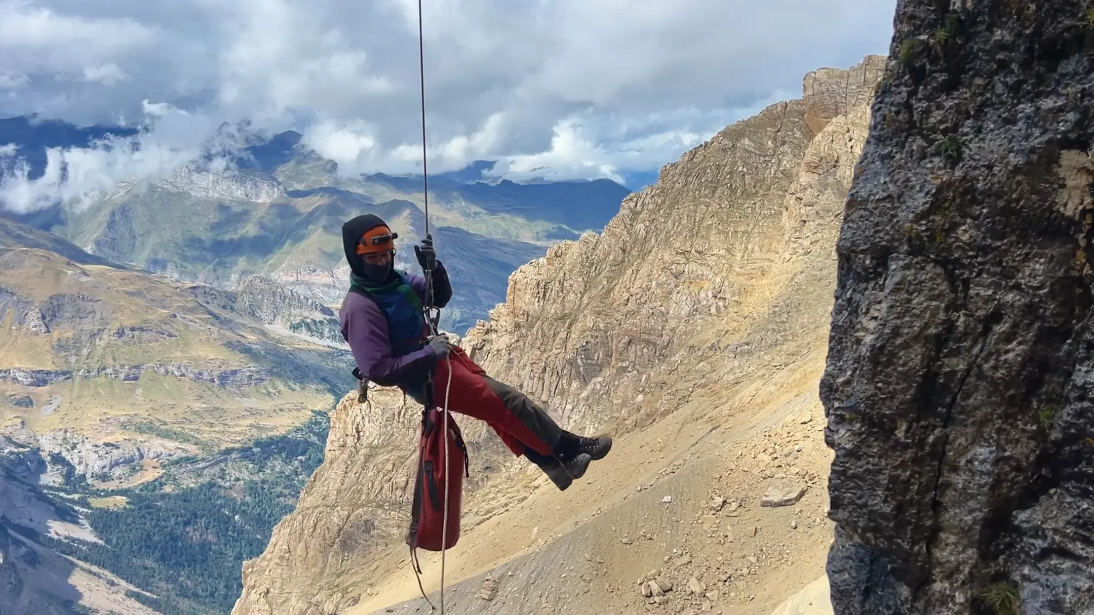 Alpiniste en descente en rappel le long d'une paroi rocheuse