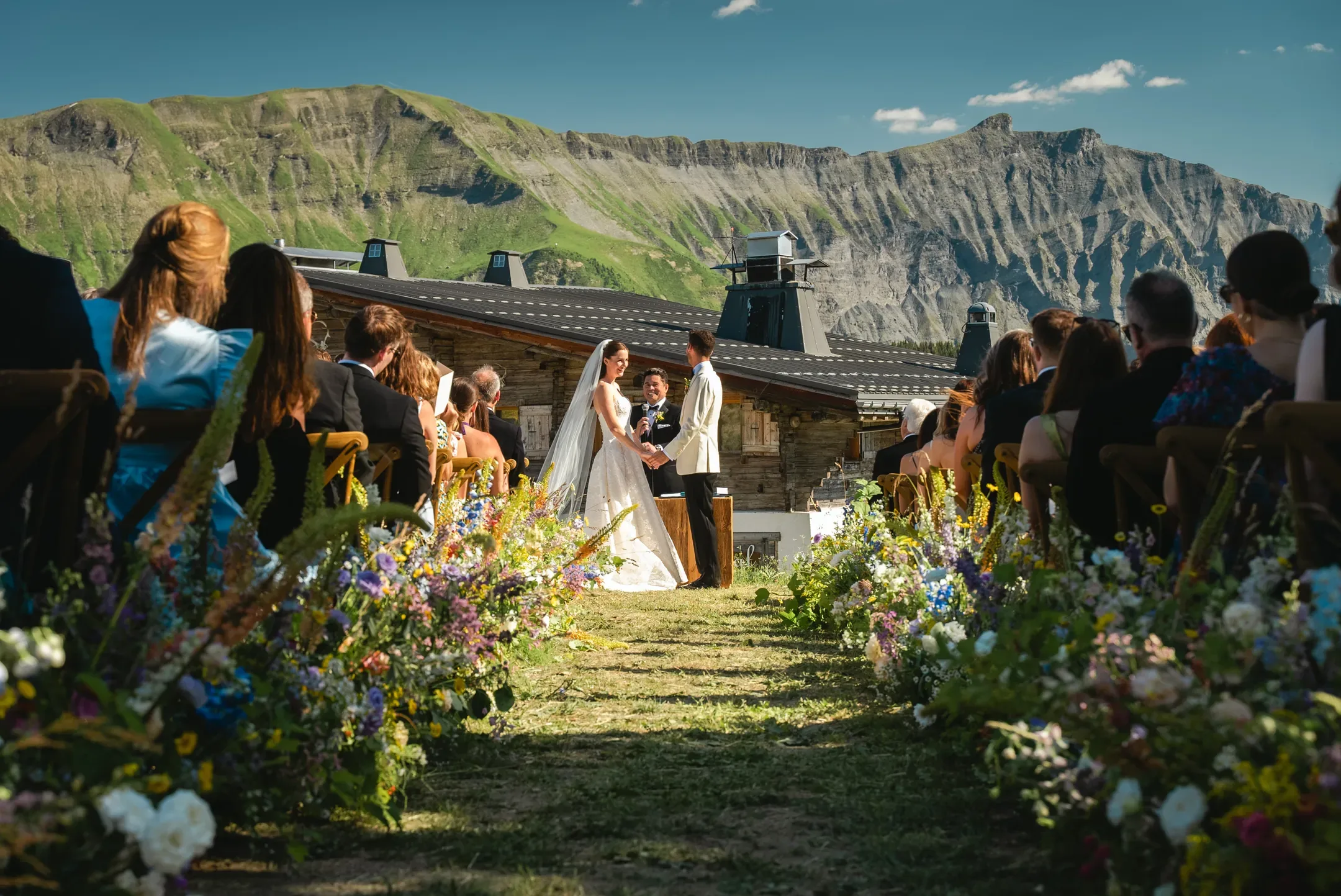 Cérémonie en plein air face aux montagnes, allée bordée de fleurs sauvages