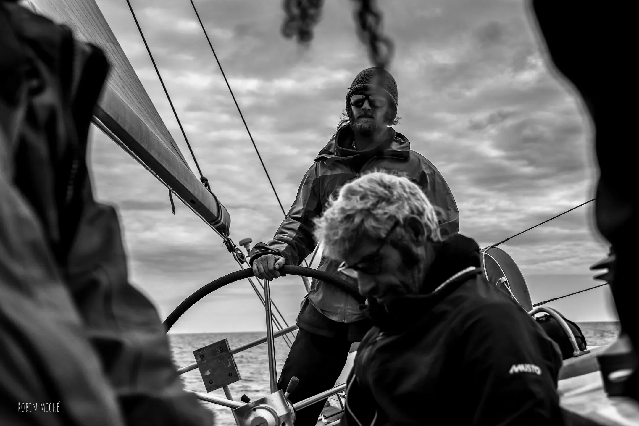 Équipiers à la barre du voilier, en noir et blanc