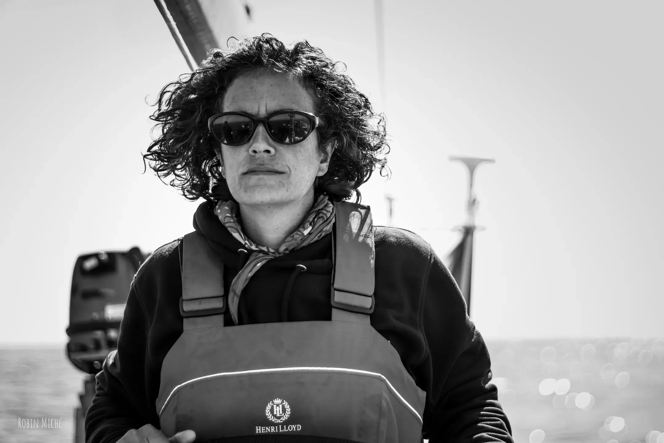 Portrait en noir et blanc d'une navigatrice en lunettes de soleil et gilet de sauvetage