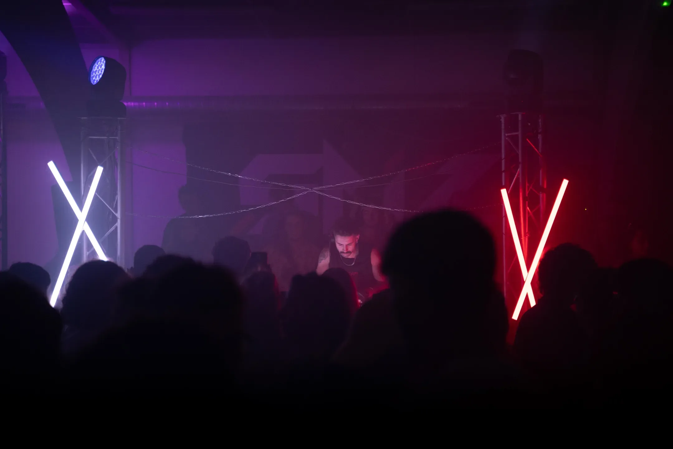 Foule devant la scène sous des lumières violettes et rouges
